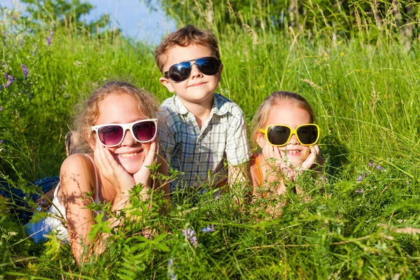 Three happy children  playing near the tree at the day time. — Zdjęcie stockowe