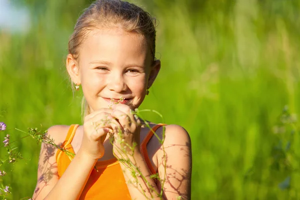 Retrato de una hermosa joven con flores silvestres en el parque — Foto de Stock