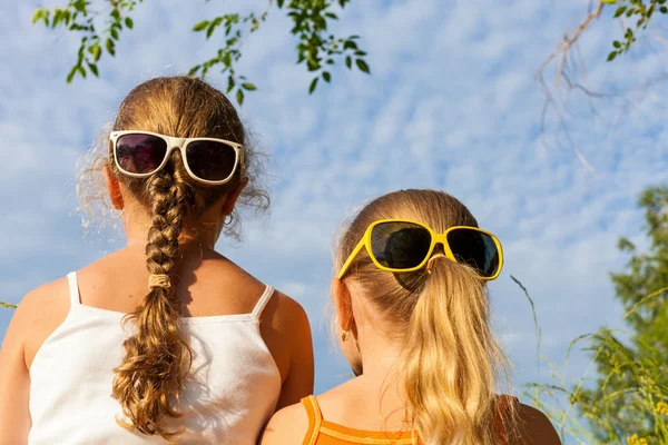 Zwei glückliche Kinder, die tagsüber in der Nähe des Baumes spielen. — Stockfoto