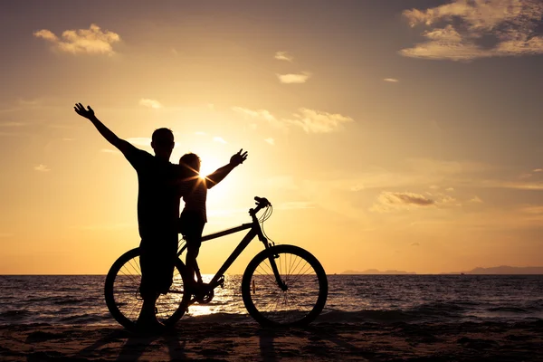 stock image Father and son playing on the beach at the sunset time.