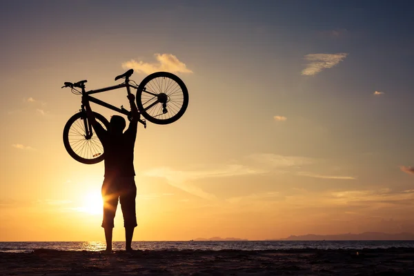 Happy man with bicycle standing on the beach — Stock Photo, Image