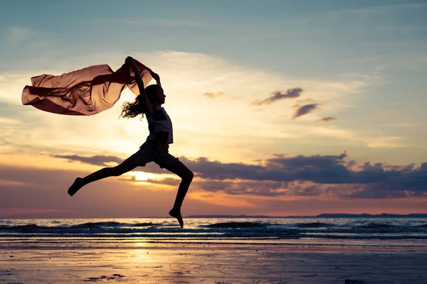 Glad flicka hoppar på stranden — Stockfoto