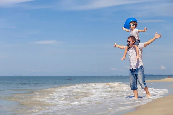 Ojciec i syn z niebieski balon gra na plaży w dzień — Zdjęcie stockowe