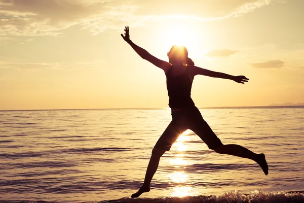 Happy girl jumping on the beach — Stock Photo, Image