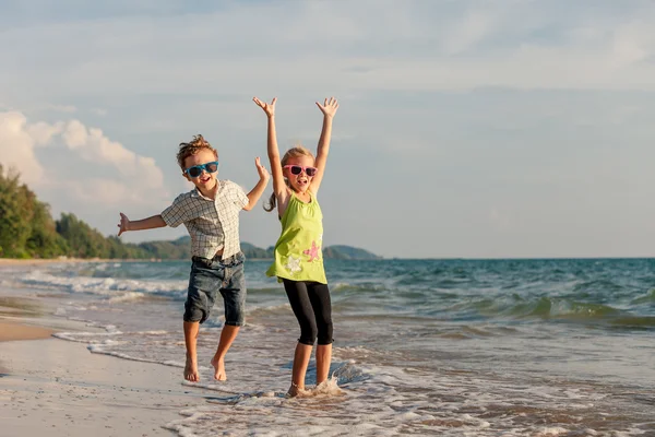 Niños felices jugando en la playa durante el día . — Foto de Stock
