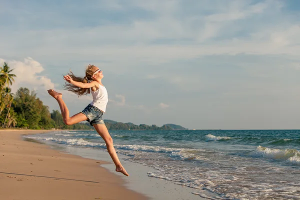 Teen flicka hoppning på stranden på dagarna. — Stockfoto