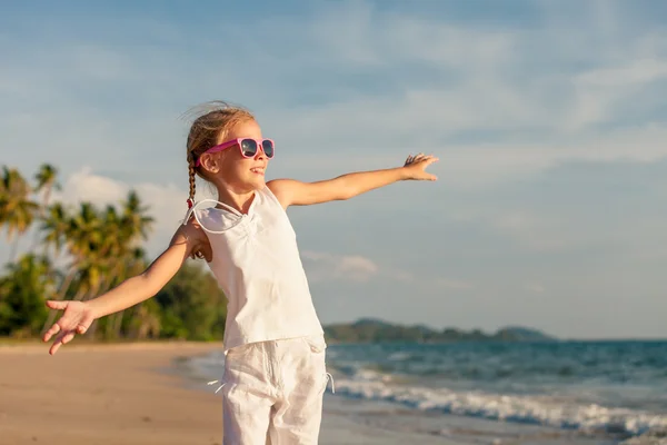 Mała dziewczynka tańczy na plaży w czasie dnia. — Zdjęcie stockowe