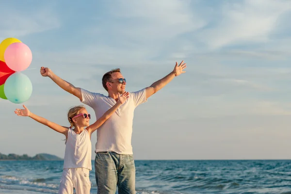 Apa és lánya léggömbökkel játszik a tengerparton: a da — Stock Fotó