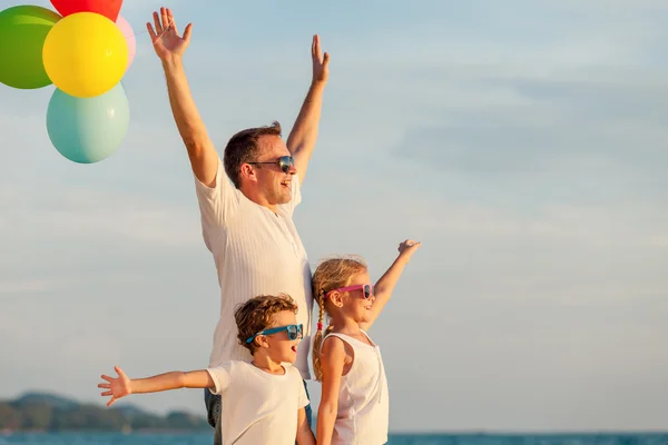 Padre e hijos con globos jugando en la playa en el da —  Fotos de Stock