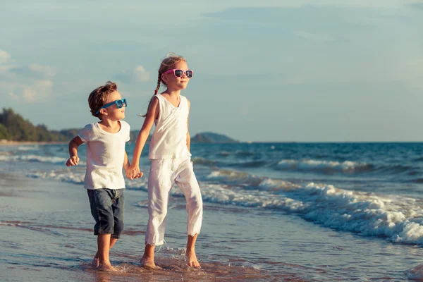 De gelukkige kinderen spelen op het strand op het moment van de dag. — Stockfoto