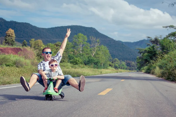 Pai e filho brincando na estrada na hora do dia . — Fotografia de Stock