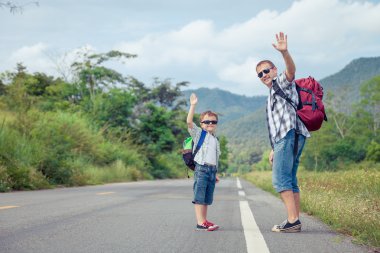Baba ve oğul gün zaman yolda yürürken.