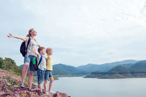 Ευτυχισμένη οικογένεια στέκεται κοντά στη λίμνη κατά τη διάρκεια της ημέρας. — Φωτογραφία Αρχείου
