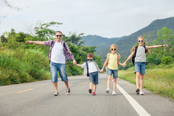 Pai e filhos caminhando na estrada durante o dia . — Fotografia de Stock