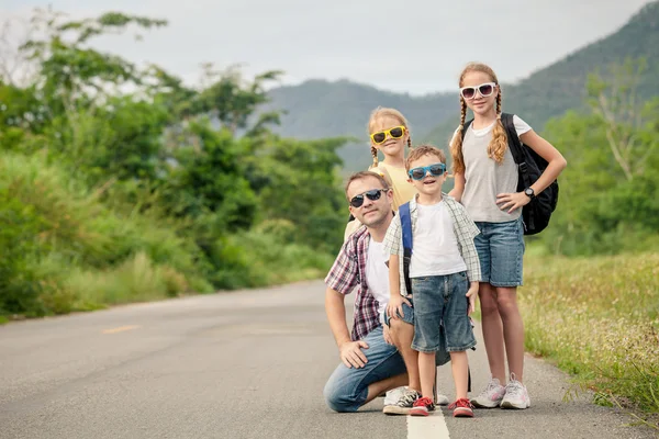 Pai e filhos caminhando na estrada durante o dia . — Fotografia de Stock