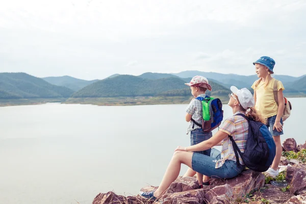 Szczęśliwa rodzina stojący w pobliżu jeziora w czasie dnia. — Zdjęcie stockowe