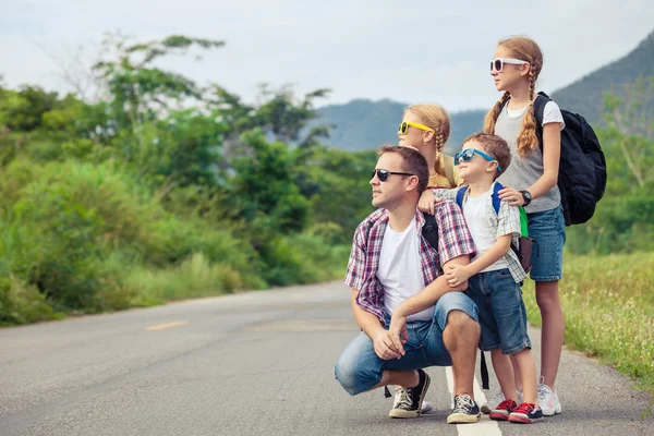 Vader en kinderen lopen op de weg op het moment van de dag. — Stockfoto