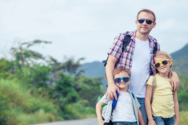 Pai e filhos caminhando na estrada durante o dia . — Fotografia de Stock