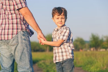 Baba ve oğul gün zaman yolda yürürken.