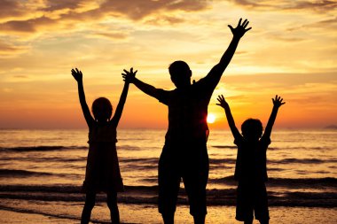 Baba ve çocuk sahilde günbatımı anda oynamak.