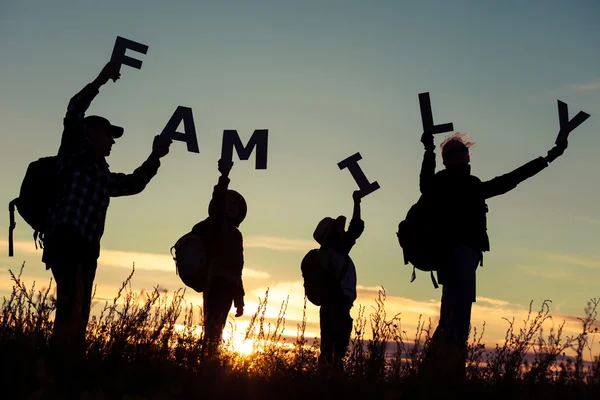 Glückliche Familie steht bei Sonnenuntergang auf dem Feld. — Stockfoto