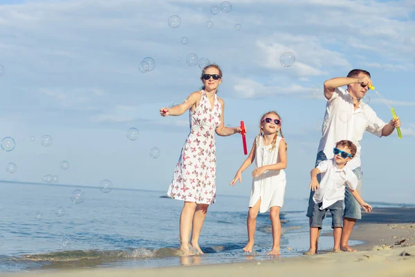 Séta a tengerparton a nap időben boldog család. — Stock Fotó