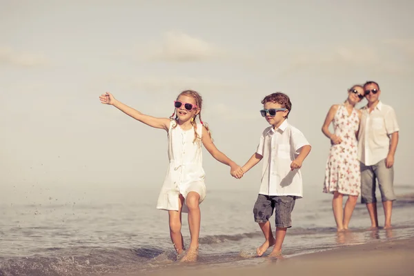 Szczęśliwa rodzina spacery na plaży w czasie dnia. — Zdjęcie stockowe