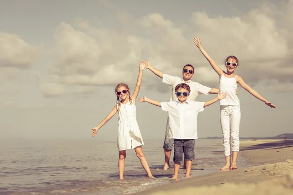 Padre e figli che giocano sulla spiaggia durante il giorno . — Foto Stock