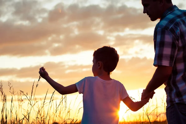 Pai e filho brincando no parque na hora do pôr do sol . — Fotografia de Stock