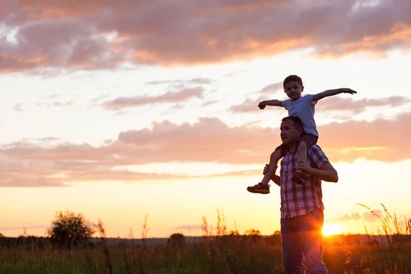 Otec a syn hraje v parku na čas západu slunce. — Stock fotografie