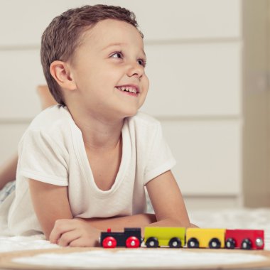 Sevimli küçük çocuk yerde yatarken oyuncaklar ile oynama.