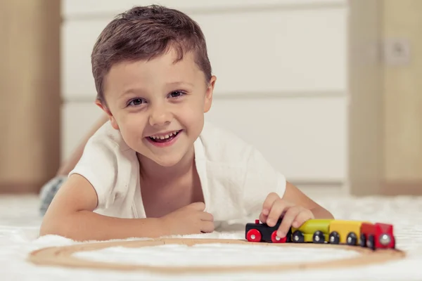 Adorable petit garçon jouant avec des jouets couchés sur le sol . — Photo