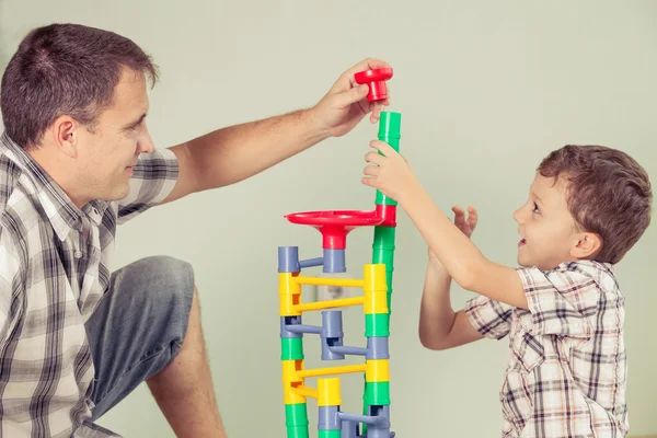 Папа с маленьким мальчиком, играющим с игрушкой на полу днем — стоковое фото