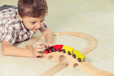 Sevimli küçük çocuk yerde yatarken oyuncaklar ile oynama.