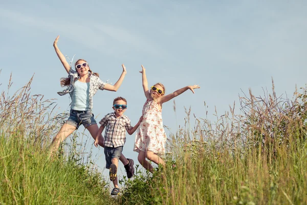 Niños felices jugando en el campo durante el día . —  Fotos de Stock