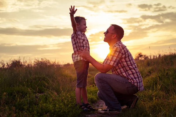 Pai e filho brincando no parque na hora do pôr do sol . — Fotografia de Stock
