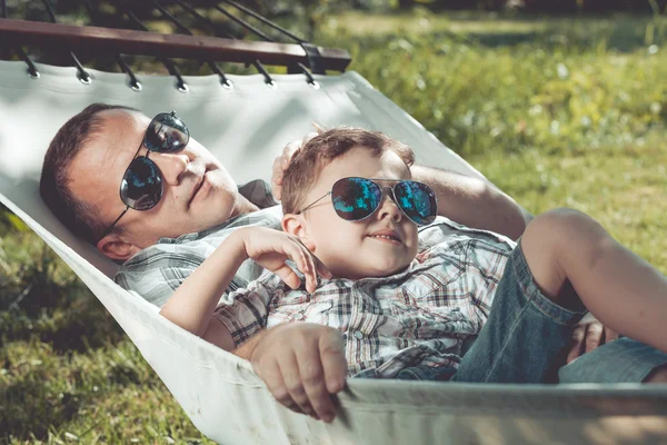 Vater und Sohn liegen auf Hängematte im Garten. — Stockfoto