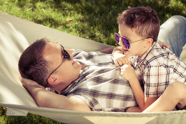 Padre e hijo tumbados en la hamaca en el jardín . — Foto de Stock