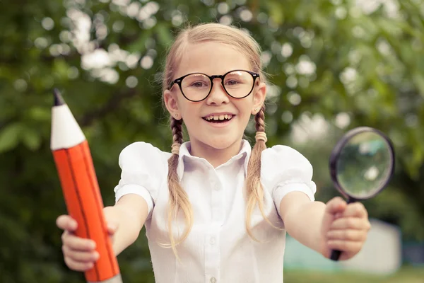 Sonriendo joven escolar en un uniforme escolar contra un árbol en — Foto de Stock