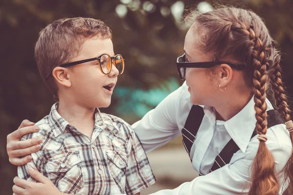 Smiling young school children in a school uniform against a tree — Stock Photo, Image