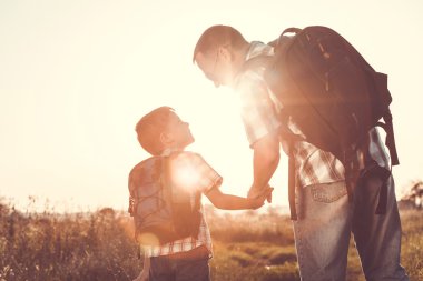 Baba ve oğul günbatımı anda parkta oynamak.