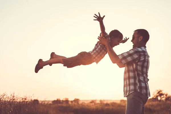 Father and son playing in the park at the sunset time. — Stock Photo, Image