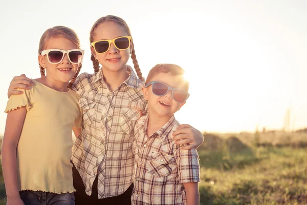 Niños felices jugando en el campo durante el día . — Foto de Stock