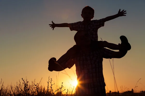 Pai e filho brincando no parque na hora do pôr do sol . — Fotografia de Stock