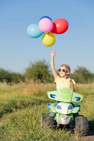 Menina feliz jogando na estrada na hora do dia . — Fotografia de Stock