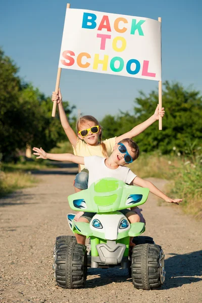 Heureux petits enfants jouant sur la route à l'heure de jour. Ils conduisent. — Photo