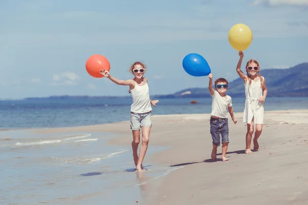 Szczęśliwe dzieci bawiące się na plaży w czasie dnia. — Zdjęcie stockowe