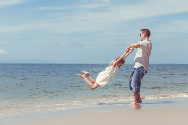 Far och dotter spelar på stranden på dagarna. — Stockfoto