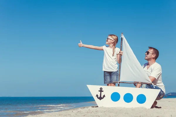 Vader en dochter spelen op het strand op het moment van de dag. — Stockfoto