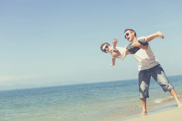 Padre e figlio che giocano sulla spiaggia durante il giorno . — Foto Stock